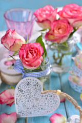 Fototapeta na wymiar romantic table decoration with pink roses and white heart