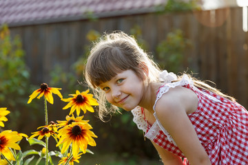 Girl six years old bent down to the flowers rudbeckia