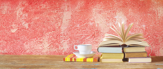 open book and cup of coffee cup on red grungy background, good copy space