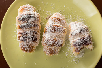 Served baked bun rolls with coconut on the plate with blurred background
