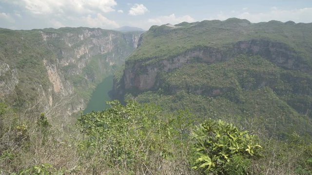 Movement along huge valley with high hills and tropical jungle river at the bottom