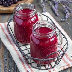 Black currant, greek yogurt, honey and lavender smoothie in glass jar, square format