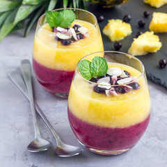 Two layer smoothie with black currant, quick oats, yogurt and pineapple, banana, square format