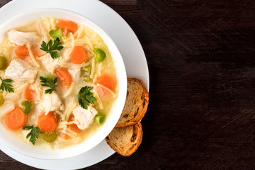 Chicken soup with noodles, overhead photo with copyspace