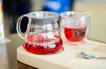 Herbal tea in glass teapot on wooden surface