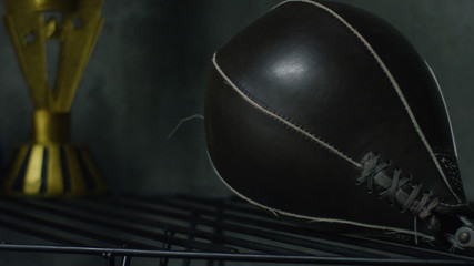 Boxing punch bag on black background. Black punching bag lying on a shelf