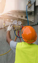 mechanic uses a pressure gauge on the air compressor