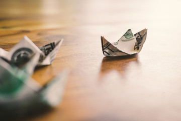 Close up dollar boat on wood table leader concept, color vintage style ,selective and soft focus