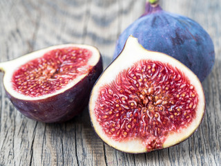 a fresh Fig and cut off half on wooden old table