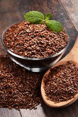 Composition with bowl of flax seeds on wooden table