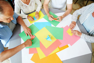 Aged companions learning how to make origami