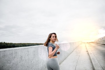 a young girl runs on the background of concrete walls at dawn