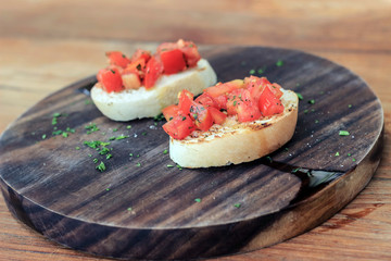 Tomato Bruschetta dish on wooden plate