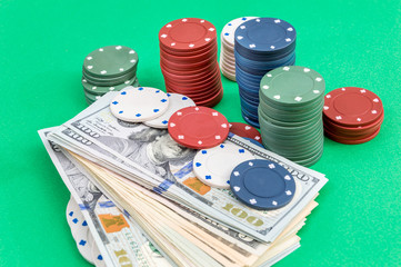 Money with poker chips on green background.