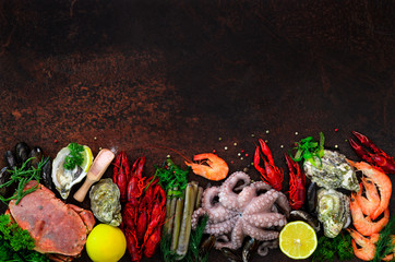 Seafood background - fresh mussels, molluscs, oysters, octopus, razor shells, shrimps, crab, crawfish, crayfish, seaweed, lemon, spices. Banner with copyspace