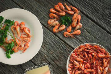 on a wooden background, white plate with shrimps