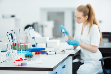Pipette dropping a sample in a test tube. Laboratory assistant analyzing blood in lab. DNA analysis