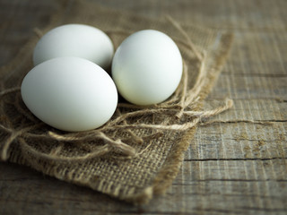 Duck eggs, white eggs, salted eggs with yolk on old sack and ropes with wooden background.