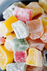 sweets and desserts, macro food, multi-colored oriental rahat tortoise, Turkish delight  in powdered sugar on a light background