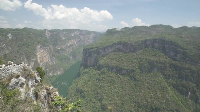 View of huge valley with high mountains and tropical jungle river at the bottom in summer sunny day