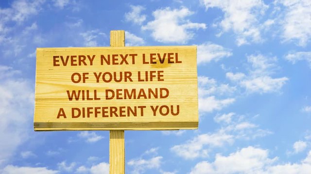 Every next level of your life will demand a different you. Words on a wooden sign against time lapse clouds in the blue sky. 