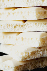 sweets and desserts, macro food, milky white  porous chocolate  on a dark background