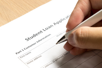 Man wait to fill information in student loan application form on desk background