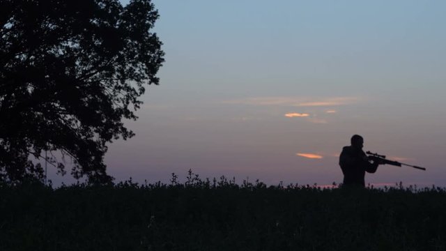 man goes hunting with a gun at sunrise 4k
