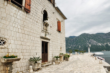 Fototapeta na wymiar Arrival to the famous Our lady of the reef Island and Church in Kotor Bay of Montenegro