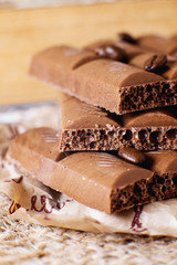 sweets and desserts, macro food, milky porous chocolate with coffee beans on a brown background