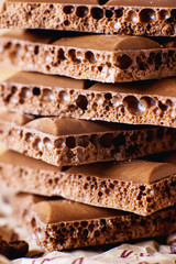 sweets and desserts, macro food, milky porous chocolate with coffee beans on a brown background