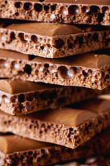 sweets and desserts, macro food, milky porous chocolate with coffee beans on a brown background