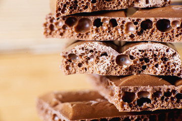 sweets and desserts, macro food, milky porous chocolate with coffee beans on a brown background