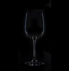 Silhouette of glass, isolated on black with blue illumination