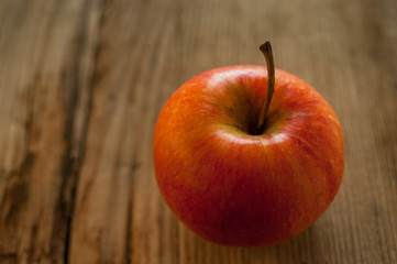 Ripe red apple on rustic dark wooden table