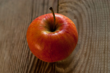 Ripe red apple on rustic dark wooden table