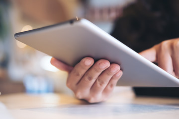 A beautiful Asian woman's hands pointing , touching and using tablet pc with blur background in cafe