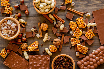 Chocolate with nuts on dark wooden background top view