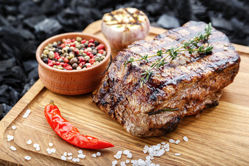 cooked steak on a wooden board