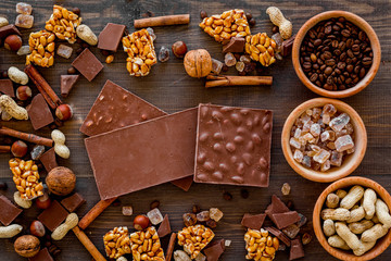 Chocolate with nuts on dark wooden background top view