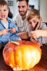 Fototapeta na wymiar Family decorating pumpkins together for Halloween