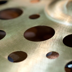thin metal surface with rhythmic apertures