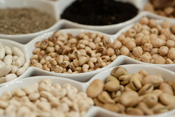 beans, chickpeas and other legumes in plates are set for an example on a show-window