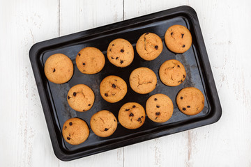 Old baking tray with homemade peanut cookies on wooden background, top view