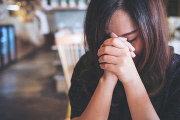 An Asian woman close her eyes to praying and wishing for a good luck