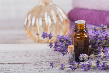 Bottle of essential oil and fresh lavender flowers