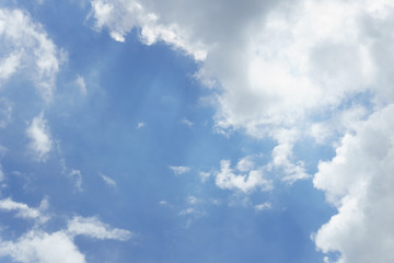 blue sky with sun behind clouds