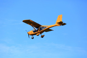Samolot awionetka ultralekki w powietrzu na błękitnym niebie. - obrazy, fototapety, plakaty