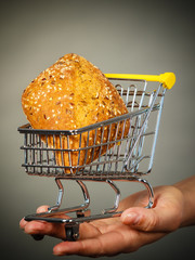Woman hand holding shopping cart with bread