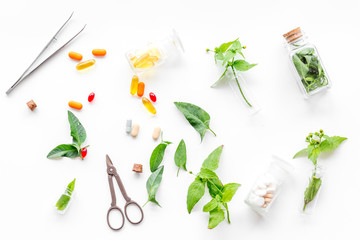 Harvest medicinal herb. Leaves, bottles and sciccors on white background top view copyspace